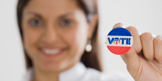 Indian woman holding up Vote pin