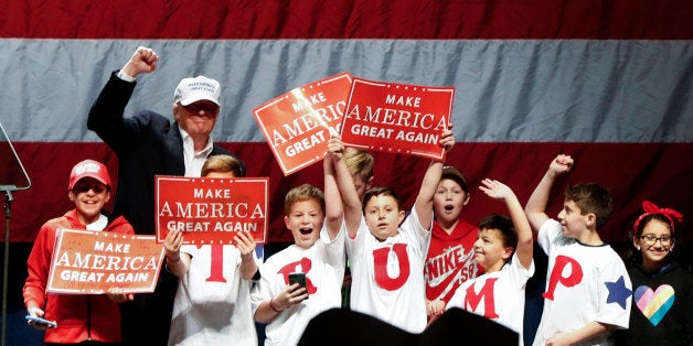 Republican presidential candidate Donald Trump poses with children on stage at a campaign rally in Sterling Heights, Mich., Sunday, Nov. 6, 2016. (AP Photo/Paul Sancya)