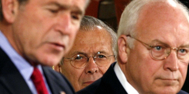 U.S. Secretary of Defense Donald Rumsfeld (C) and Vice President Dick Cheney listen to U.S. President George W. Bush speak be
