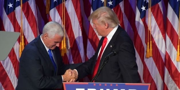 Republican presidential elect Donald Trump (R) shakes hands with Republican candidate for Vice President Mike Pence speak during election night at the New York Hilton Midtown in New York on November 9, 2016. / AFP / JIM WATSON (Photo credit should read JIM WATSON/AFP/Getty Images)