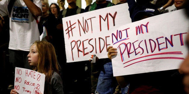 A girl joins demonstrators to protest outside of City Hall following the election of Republican Donald Trump as President of