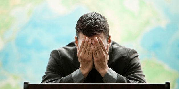 Frustrated Hispanic businessman standing at podium