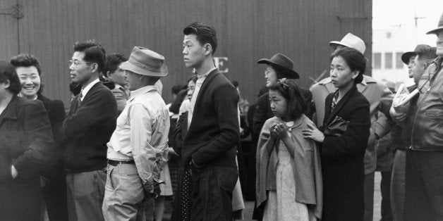 Japanese-Americans in Los Angeles, California, watching a train take their friends and relatives to the Owens Valley internment camp. Japanese-Americans were evacuated from certain West Coast areas under US Army War Emergency Order. April 1942. (Photo by Â© CORBIS/Corbis via Getty Images)