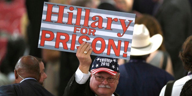 A Donald Trump supporter holds a sign on the floor of the Quicken Loans Arena before the start of the Republican National Convention in Cleveland, Monday, July 18, 2016. (AP Photo/Mark J. Terrill)