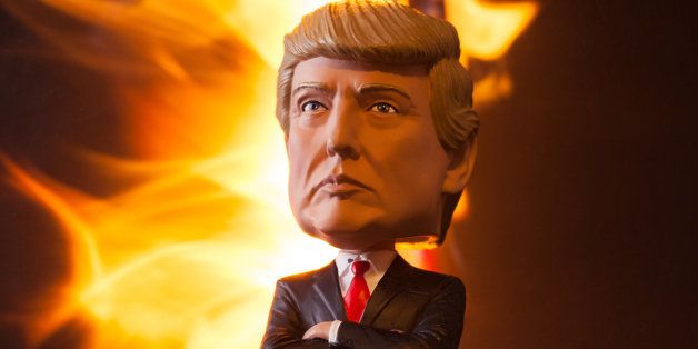 Lexington, Kentucky, USA - November 1, 2016: Lifelike bobblehead doll of Republican Donald Trump peers out from a burning, apocalyptic landscape. This realistic bobblehead figure became popular prior to the 2016 presidential election and is one of several dolls marketed by Royal Bobbles. Donald Trump and Hillary Clinton faced off as Republican and Democratic candidates during their 2016 race for the title of President of the United States. Millions in the US and the world are concerned about the destructive potential of a Trump presidency.