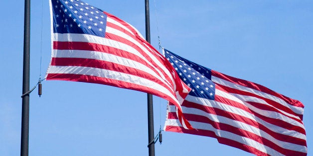 'Two flags selected from a group flying at half-staff on Septmeber 11. Two flagpoles reinforce the number 11, as well as the