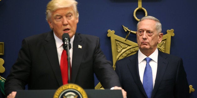 U.S. Defense Secretary James Mattis (R) listens to remarks by U.S. President Donald Trump after a swearing-in ceremony for M