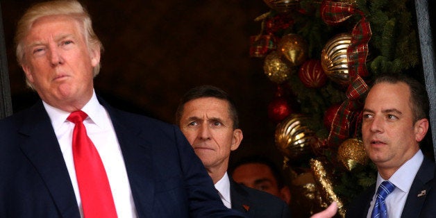 Incoming White House Chief of Staff Reince Priebus (R) and U.S. Army Lieutenant General Michael Flynn (C) look at U.S. President-elect Donald Trump as he talks with the media at Mar-a-Lago estate where Trump attends meetings, in Palm Beach, Florida, U.S., December 21, 2016. REUTERS/Carlos Barria