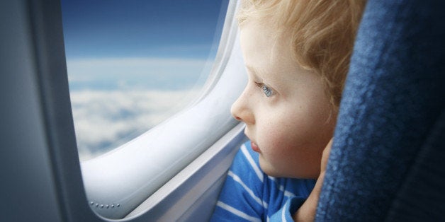 Curious little boy watching the sky through the airplane window. Shallow DOF. See more of this little boy: