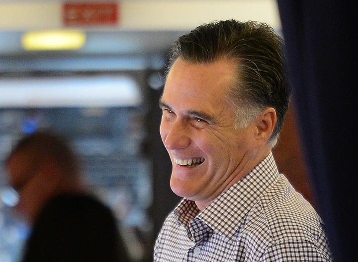 US Republican presidential candidate Mitt Romney speaks with campaign staff after boarding his campaign plane at Washington Dulles International Airport in Chantilly, Virginia October 18, 2012. AFP PHOTO/Emmanuel DUNAND (Photo credit should read EMMANUEL DUNAND/AFP/Getty Images)