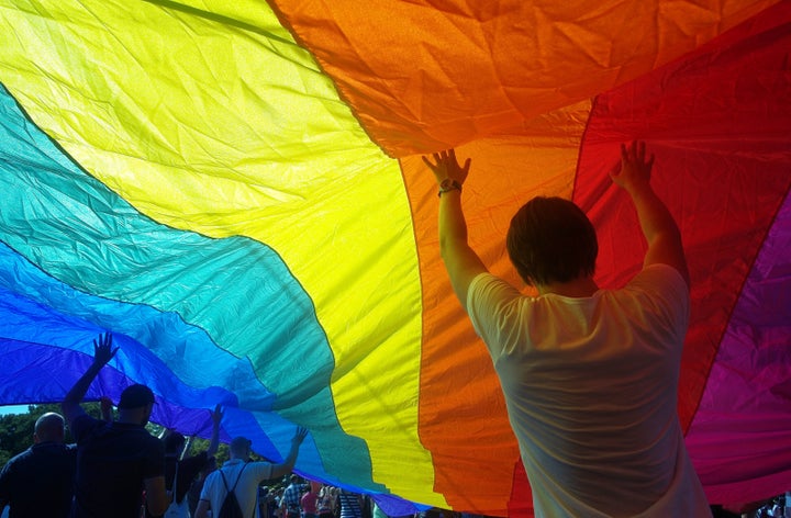 People hold up a large rainbow flag as they take part in the second gay pride festival in the Czech capital Prague on August 18, 2012. Thousands marched in Prague today for the climax of the Czech capital's second gay pride festival, using the occasion to condemn the sentencing of Russia's Pussy Riot punk band. AFP PHOTO/ MICHAL CIZEK (Photo credit should read MICHAL CIZEK/AFP/GettyImages)