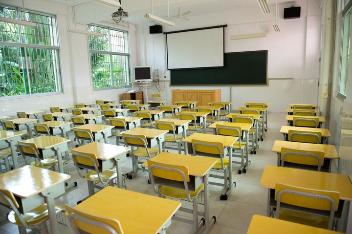 desk and chairs in classroom.