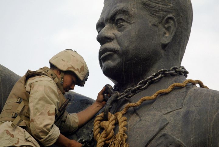 Baghdad, IRAQ: TO GO WITH AFP STORIES ON ANNIVERSARY OF THE FALL OF BAGHDAD: (FILES) A US Marine chains the head of a statue of Iraqi leader Saddam Hussein before pulling it down in Baghdad's al-Fardous (paradise) square 09 April 2003. Four years after US marines toppled the towering statue, marking the end of an iron-fisted regime, Iraq is battling to quell civil strife threatening the entire region. Saddam and three of his aides have been hanged, six are on trial for genocide and war crimes, and Iraq has descended into a quagmire of communal bloodletting that has killed tens of thousands of civilians. Jubilant Baghdadis who welcomed US tanks on that fateful day now blame the dire situation on what even some of the country's most senior leaders brand an unwanted US-led 'occupation.' AFP PHOTO/RAMZI HAIDAR (Photo credit should read RAMZI HAIDAR/AFP/Getty Images)