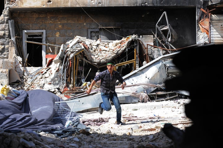 A Syrian opposition fighter runs for cover from Syrian army snipers during clashes in the northern city of Aleppo on March 27