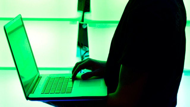 HAMBURG, GERMANY - DECEMBER 28: A participant holds his laptop in front of an illuminated wall at the annual Chaos Computer Club (CCC) computer hackers' congress, called 29C3, on December 28, 2012 in Hamburg, Germany. The 29th Chaos Communication Congress (29C3) attracts hundreds of participants worldwide annually to engage in workshops and lectures discussing the role of technology in society and its future. (Photo by Patrick Lux/Getty Images)