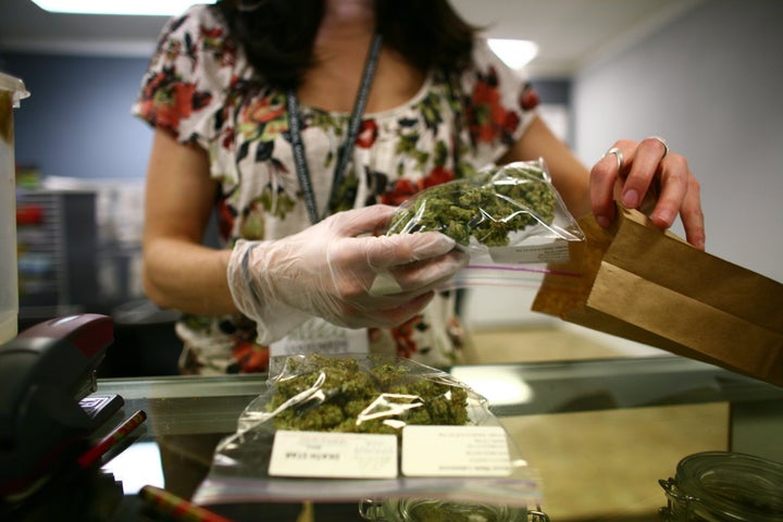 Lakewood, CO - MARCH, 4: Sales associate, Crystal Guess packages up a patient's cannabis inside a Good Meds medical cannabis