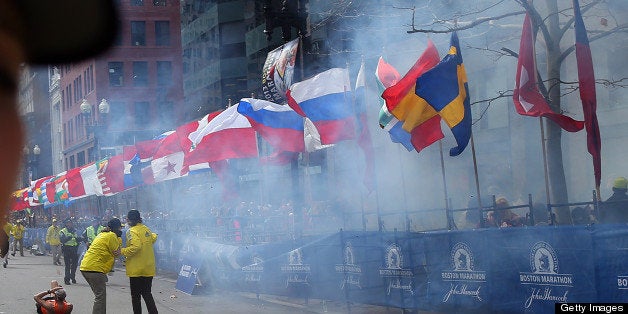 BOSTON - APRIL 15: Officials react as the first explosion goes off on Boylston Street near the finish line of the 117th Boston Marathon on April 15, 2013. (Photo by John Tlumacki/The Boston Globe via Getty Images)