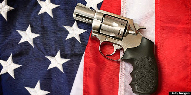 A handgun resting on an American flag, representing the Second Amendment of the US Constitution, the right of patriotic Americans to bear arms. Social issues concept.