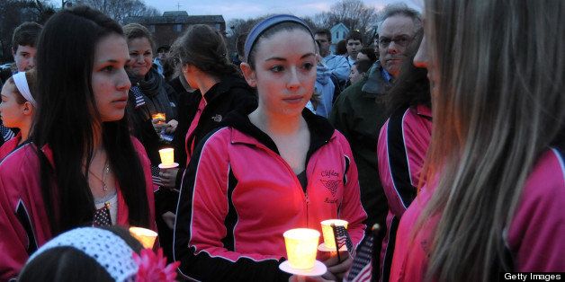 Students from the Clifden Academy hold an American flag and candles during a vigil ceremony April 16, 2013 in Dorcester, Massachusetts, honoring the Richard family, who's 8-year-old son Martin was killed, and sister Jane, who lost a leg and had danced at the school, and mother Denise, who was also seriously injured when bombs exploded at the finish of the Boston Marathon April 15th. AFP PHOTO/John MOTTERNAFP PHOTO / John MOTTERN (Photo credit should read JOHN MOTTERN/AFP/Getty Images)