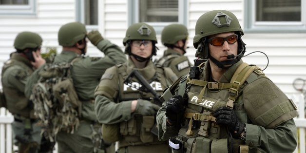 A police SWAT team search houses for the second of two suspects wanted in the Boston Marathon bombings takes place April 19,