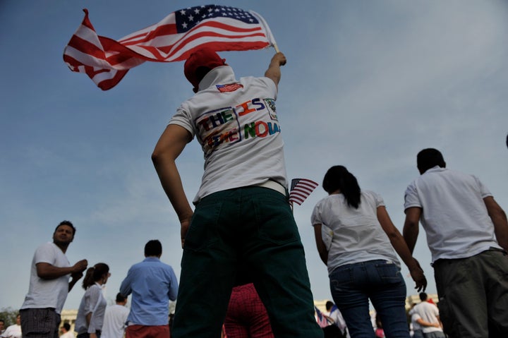 WASHINGTON, DC - APRIL 10: A rally supporter raises an American flag in support of the immigration reform rally on Capitol Hi