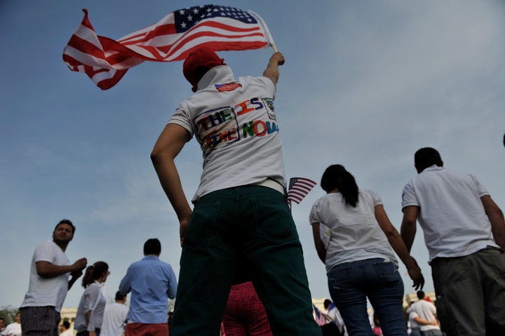 WASHINGTON, DC - APRIL 10: A rally supporter raises an American flag in support of the immigration reform rally on Capitol Hill. (Photo by Marlon Correa/The Washington Post via Getty Images)