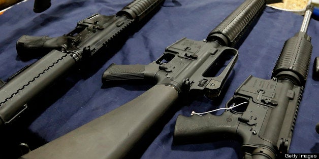 A semi-automatic assault rifle made by Bushmaster Firearms International LLC, , center, is displayed with other guns for sale