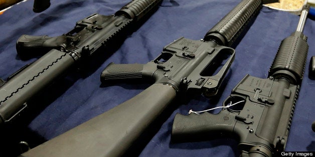 A semi-automatic assault rifle made by Bushmaster Firearms International LLC, , center, is displayed with other guns for sale at the Rocky Mountain Gun Show in Sandy, Utah, U.S., on Saturday, Jan. 5, 2013. A working group led by Vice President Joe Biden is seriously considering measures that would require universal background checks for firearm buyers, track the movement and sale of weapons through a national database, strengthen mental health checks and stiffen penalties for carrying guns near schools or giving them to minors. Photographer: George Frey/Bloomberg via Getty Images