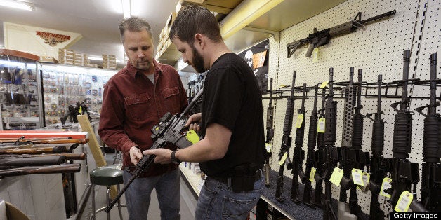 Sales representative Jason Brown, right, shows Steve Levy, of Rolesville, North Carolina, an AR-15 assault rifle manufactured by Core15 Rifle Systems at Perry's Gun Shop in Wendell, N.C., on Tuesday, December 17, 2012. The weapon costs $2,384 and features an EoTech optical sighting system and a 30-round magazine capacity. (Chuck Liddy/Raleigh News & Observer/MCT via Getty Images)