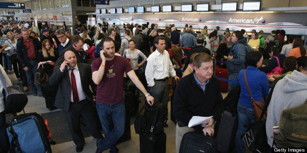 CHICAGO, IL - APRIL 16: American Airlines passengers wait in line to reschedule flights at O'Hare Airport on April 16, 2013