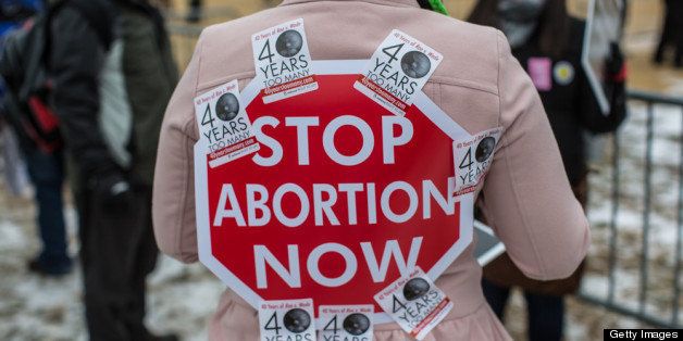 WASHINGTON, DC - JANUARY 25: An anti-abortion protester has a sign stuck to her back with stickers at the March for Life on January 25, 2013 in Washington, DC. The pro-life gathering is held each year around the anniversary of the Roe v. Wade Supreme Court decision. (Photo by Brendan Hoffman/Getty Images)