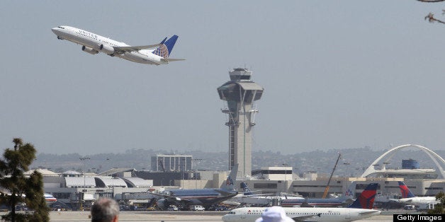 LOS ANGELES, CA - APRIL 22: People watch as a United Airlines jet passes the air traffic control tower at Los Angles International Airport (LAX) during take-off on April 22, 2013 in Los Angeles, California. Delays have been reported throughout the nation because of the furloughing of air traffic controllers under sequestration. The average delay overnight in the Southern California Terminal Radius Approach Control (TRACON) was was three hours. (Photo by David McNew/Getty Images)