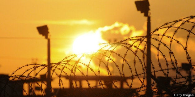 The sun rises over the Camp Delta detention center at the U.S. naval base at Guantanamo Bay, Cuba, on Thursday, Oct. 18, 2012. Khalid Sheikh Mohammed, the accused mastermind of the Sept. 11, 2001, terrorist attacks, urged a military judge at the U.S. naval base at Guantanamo Bay yesterday to avoid using an expansive definition of national security that the defendant said would justify torture and killing. Photographer: Michelle Shepard/Pool via Bloomberg