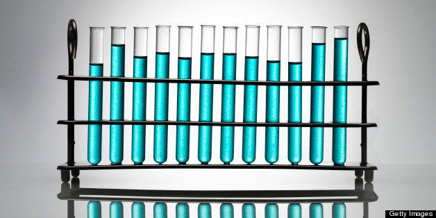 Chemistry test tubes containing blue liquid on a white background