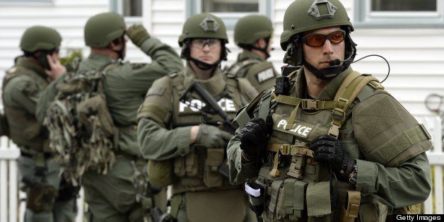 A police SWAT team search houses for the second of two suspects wanted in the Boston Marathon bombings takes place April 19, 2013 in Watertown, Massachusetts. Thousands of heavily armed police staged an intense manhunt Friday for a Chechen teenager suspected in the Boston marathon bombings with his brother, who was killed in a shootout. Dzhokhar Tsarnaev, 19, defied the massive force after his 26-year-old brother Tamerlan was shot and suffered critical injuries from explosives believed to have been strapped to his body. AFP PHOTO / TIMOTHY A. CLARY (Photo credit should read TIMOTHY A. CLARY/AFP/Getty Images)