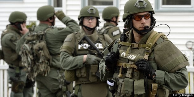 A police SWAT team search houses for the second of two suspects wanted in the Boston Marathon bombings takes place April 19,