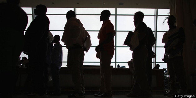 MIAMI, FL - MAY 02: People looking for work stand in line to apply for a job during a job fair at the Miami Dolphins Sun Lif