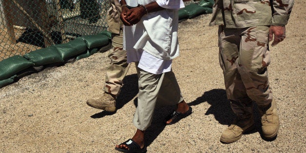 GUANTANAMO BAY, CUBA - SEPTEMBER 16: (EDITORS NOTE: Image has been reviewed by the U.S. Military prior to transmission.) U.S. military guards move an 'enemy combatant' within the detention center on September 16, 2010 in Guantanamo Bay, Cuba. With attempts by the Obama administration to close the facility stalled, more than 170 detainees remain at the detention center. The facility is run by the Joint Task Force Guantanamo, located on the U.S. Naval Station at Guantanamo Bay, which is the oldest American naval base outside of the continental United States. (Photo by John Moore/Getty Images)