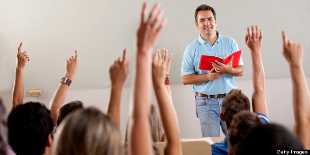 Hispanic college students raising arms in classroom