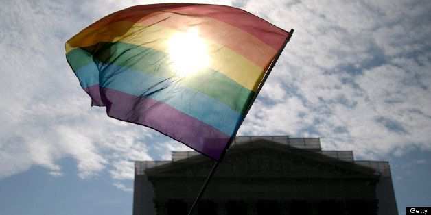 Vin Testa, a supporter of same-sex marriage, waves a rainbow colored flag outside the U.S. Supreme Court while waiting for a ruling on two gay-marriage cases in Washington, D.C., U.S., on Monday, June 24, 2013. A historic week at the U.S. Supreme Court may transform the rights of racial minorities and gays, potentially cutting longstanding voting protections for blacks and Hispanics while allowing a new wave of same-sex marriages. Photographer: Andrew Harrer/Bloomberg via Getty Images 