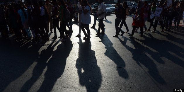 Shadows are cast of Indian students walking at a peace rally on the 65th death anniversary of 'father of the nation' Mahtama Gandhi, in Mumbai on January 30, 2013. Students and people from various walks of life took part in the rally for peace and communal harmony. AFP PHOTO/Indranil MUKHERJEE (Photo credit should read INDRANIL MUKHERJEE/AFP/Getty Images)