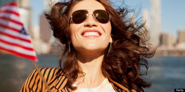 Smiling woman waving American flag