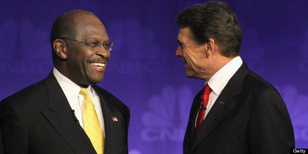 ROCHESTER, MI - NOVEMBER 09: Republican presidential candidates businessman Herman Cain (L) and Texas Governor Rick Perry chat before a debate hosted by CNBC and the Michigan Republican Party at Oakland University on November 9, 2011 in Rochester, Michigan. The debate is the first meeting of the eight GOP presidential hopefuls since allegations of sexual impropriety have surfaced against front-runner Herman Cain. (Photo by Scott Olson/Getty Images)