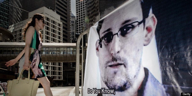 A woman walks past a banner displayed in support of former US spy Edward Snowden in Hong Kong on June 18, 2013. The 29-year-