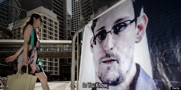 A woman walks past a banner displayed in support of former US spy Edward Snowden in Hong Kong on June 18, 2013. The 29-year-old former contractor for the National Security Agency dismissed allegations he was a traitor or a Chinese agent, and insisted he had exposed a dangerous US global surveillance network that threatens the privacy of millions. AFP PHOTO / Philippe Lopez (Photo credit should read PHILIPPE LOPEZ/AFP/Getty Images)