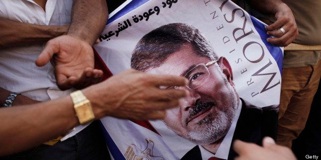 CAIRO, EGYPT - JULY 8: A poster of deposed Egyptian President Mohammed Morsi held by supporters during a demonstration at the Rabaa al-Adweya Mosque in the Nasr City district on July 8, 2013 in Cairo, Egypt. Egyptian health ministry officials are reporting at least 50 people were killed and more than 300 injured when the Egyptian military aledgedly opened fire as pro-Morsi supporters attending a sit-in were performing dawn prayer. The demonstrators were demanding the release of Morsi, who they believe is being held inside the Republican Guard headquarters. (Photo by Ed Giles/Getty Images)