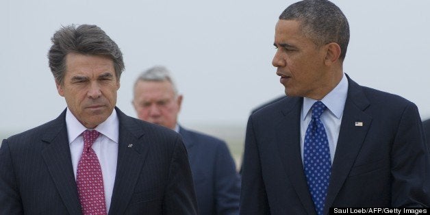 US President Barack Obama speaks with Texas Governor Rick Perry (L) after arriving on Air Force One at Austin-Bergstrom International Airport in Austin, Texas, May 9, 2013. Obama will speak on the economy and job creation. AFP PHOTO / Saul LOEB (Photo credit should read SAUL LOEB/AFP/Getty Images)