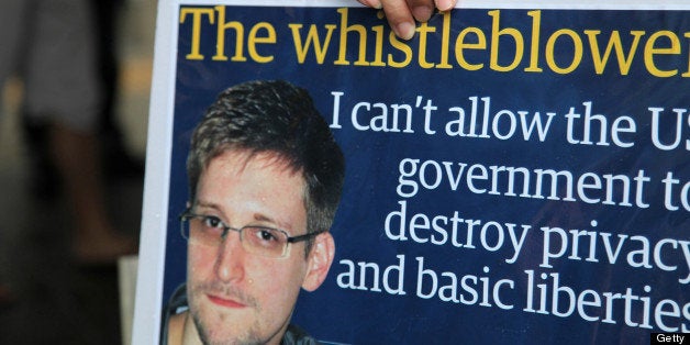 A protester holds a placard during a rally in support of Edward Snowden, the former National Security Agency contractor, in Hong Kong, China, on Saturday, June 15, 2013. Protesters marched to Hong Kongs government headquarters demanding their leaders protect Edward Snowden, who fled to the city after exposing a U.S. surveillance program. Photographer: Luke Casey/Bloomberg via Getty Images