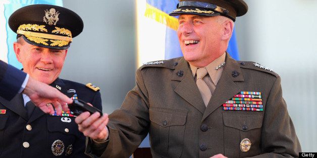 DORAL, FL - NOVEMBER 19: U.S. Marine General John F. Kelly (R) shares a laugh with U.S Army General Martin E. Dempsey, Chairman, Joint Chiefs of Staff, as he is handed a Blackberry phone by U.S. Air Force General Douglas Fraser during a change of command ceremony at United States Southern Command on November 19, 2012 in Doral, Florida. U.S. Marine Gen. John Kelly takes over the command from U.S. Air Force Gen. Douglas Fraser. (Photo by Joe Raedle/Getty Images)