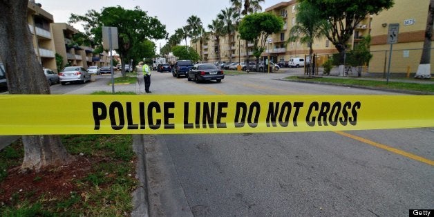 Police tape blocks the street to an apartment building after a shooting incident which began Friday evening left seven people
